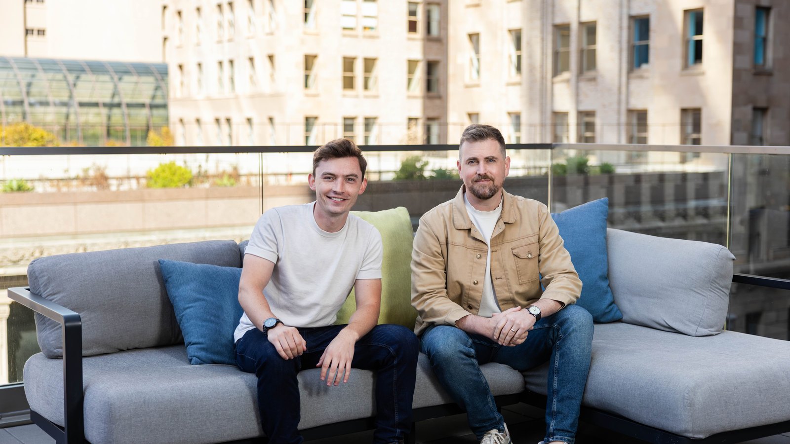 Official General Compute press photo of co-founders Finn Puklowski (CEO) and Jason Goodison (CTO) seated on a rooftop sofa in San Francisco